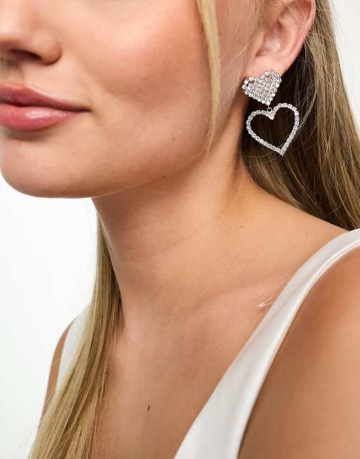 Pendientes plateados con diseño de dos corazones de pedrería de True Decadence