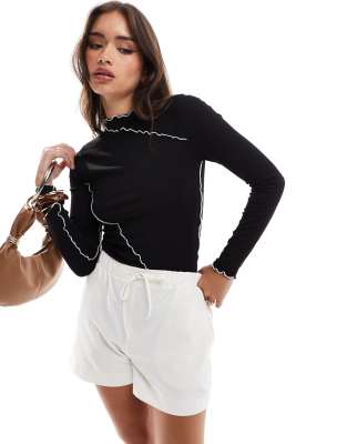 long sleeve top with contrast lettuce edge detail in black