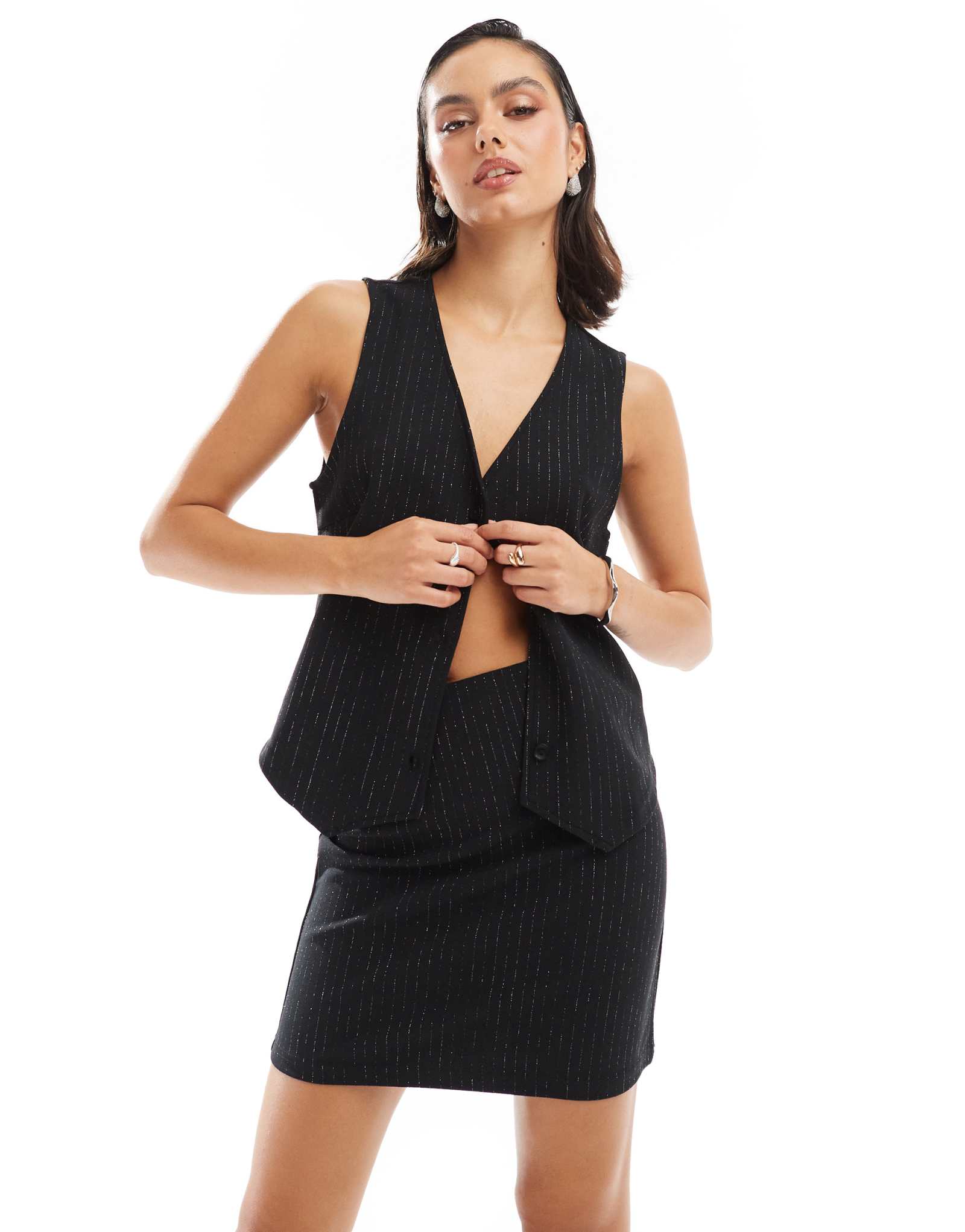 Детали сочетаются друг с другом, черная мини-юбка в блестящую полоску - часть комплекта