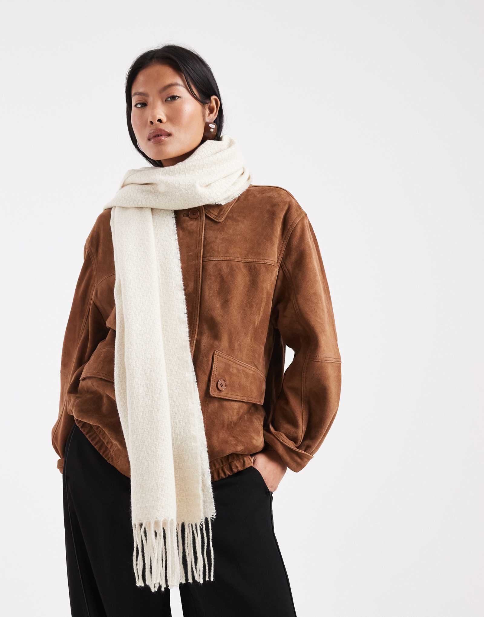 Кусочки мягкого текстурированного шарфа с кисточкой кремового цвета