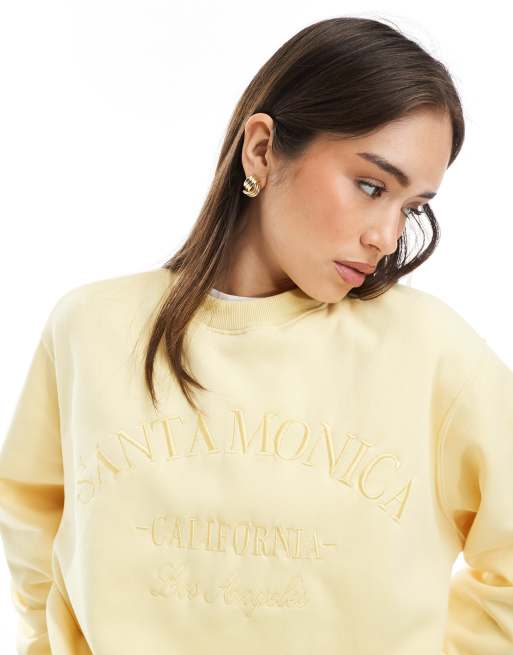 Pimkie 'Santa Monica' embroidered text sweatshirt in yellow | ASOS