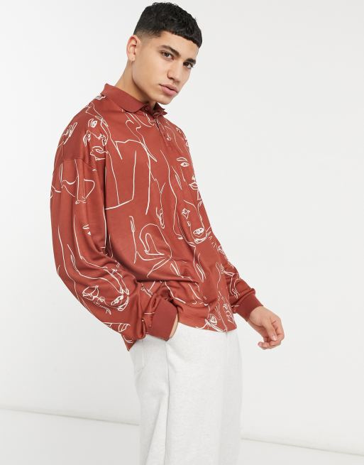 Polo extragrande de manga larga con estampado integral de rostros delineados de ASOS DESIGN