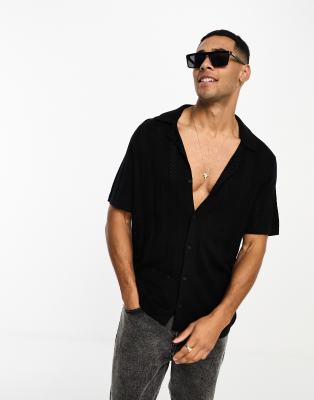 Polo negro con botones y pespuntes estilo croché de Hollister