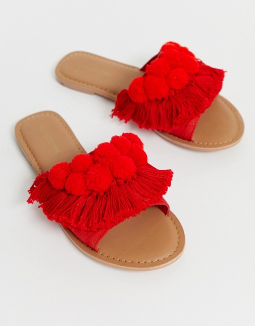 PrettyLittleThing flat sandals with fringe and pom pom detail in red