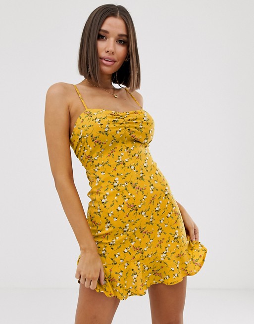 PrettyLittleThing mini dress with open back and flippy hem in yellow ditsy