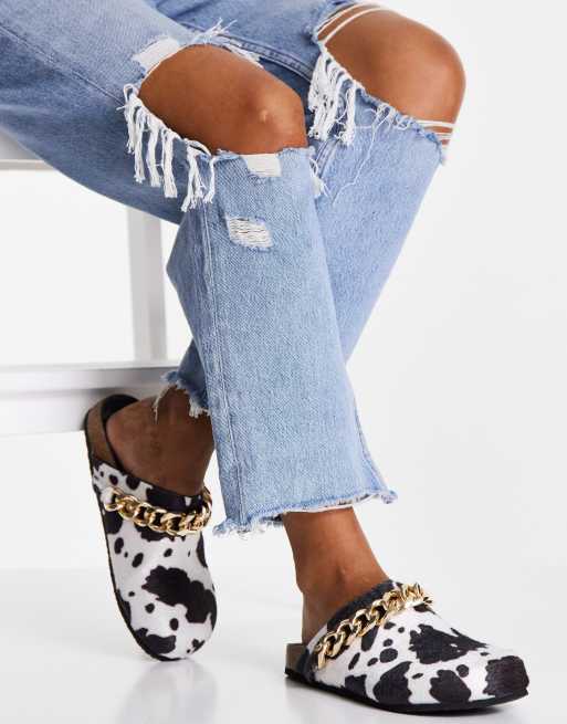 Public Desire – Isabel – Clogs mit Kettenbesatz und Kuhmuster