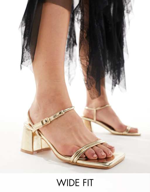 Public Desire Wide Fit – Oracle – Goldfarbene Sandalen mit mittelhohem Absatz