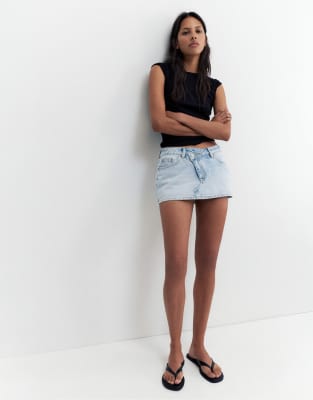 Pull&Bear – Blekblå skort i denim med korsad design — kjol med fickor från ASOS