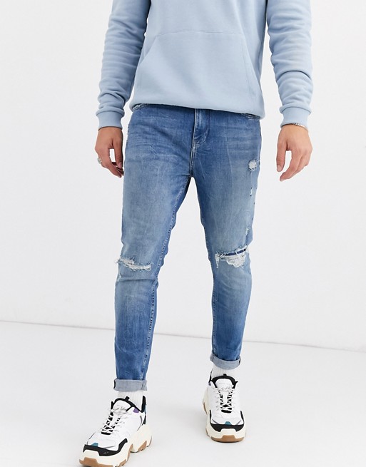 Pull&Bear jeans in carrot fit with rip and repair mid blue