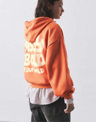 Pull & Bear - Kapuzenpullover in Orange mit Schriftzug in Spray-Optik