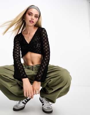 Pull & Bear - Langärmliges, kurzes Pointelle-Oberteil in Schwarz mit verdrehter Vorderseite