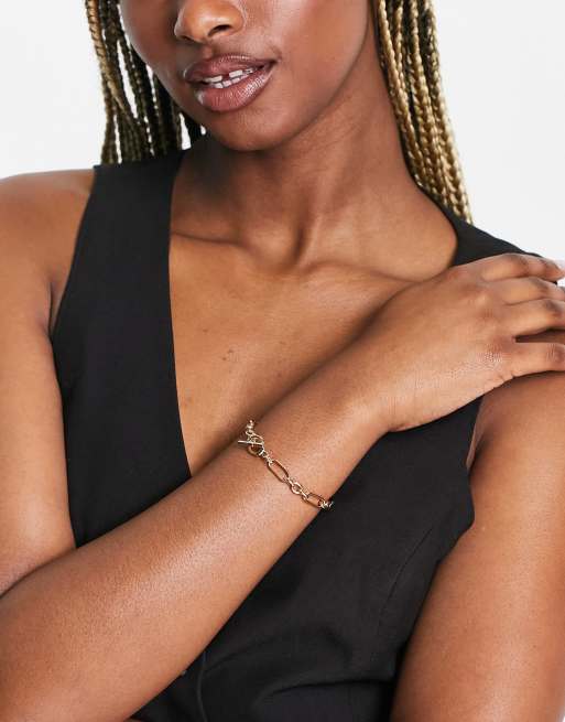 Pulsera dorada con diseño de cadena variada y cierre de barra en forma de "T" de ASOS DESIGN |