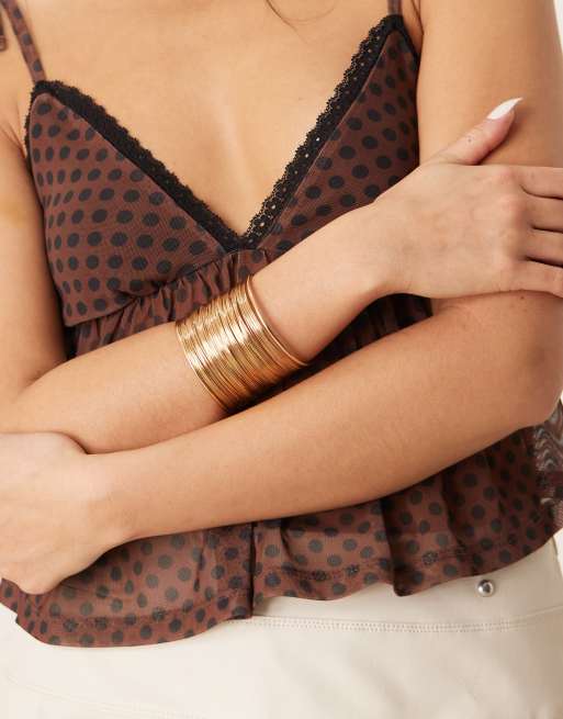 Pulsera dorada estilo brazalete con diseño de alambres de DesignB London