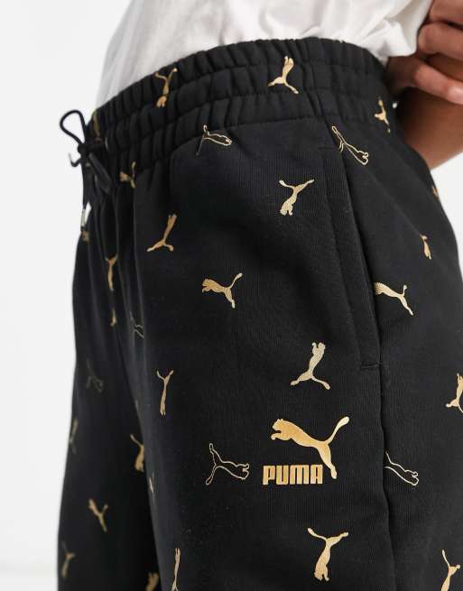 Puma Classics all over logo print sweatpants in black and gold