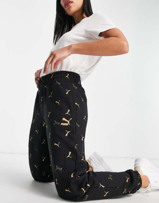 Puma Classics all over logo print sweatpants in black and gold