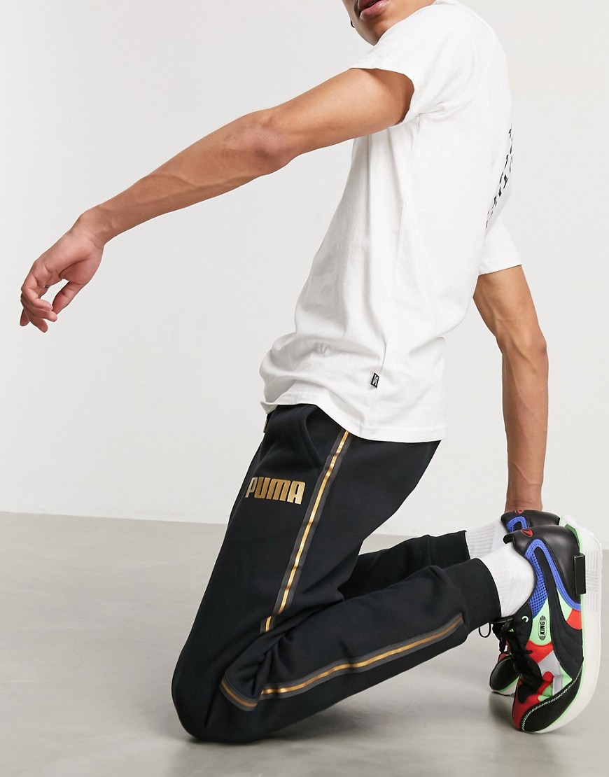 Puma sweatpants in black with gold taping