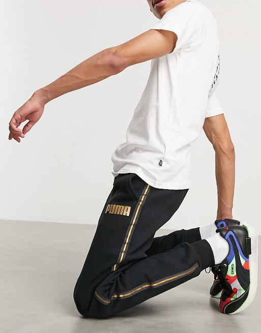 Puma sweatpants in black with gold taping | ASOS