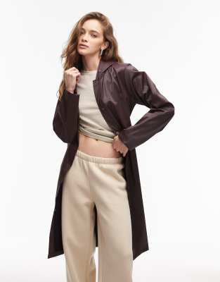 Rains - 12020 - Wasserdichte, längere Jacke in Kastanienbraun mit Bindegürtel und A-Linien-Schnitt