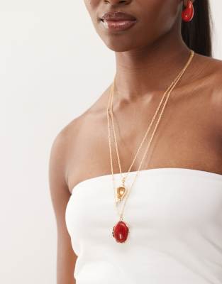 Reclaimed Vintage - Collier double-rang long avec pendentifs coquillage et pierre rouge fantaisie - Doré
