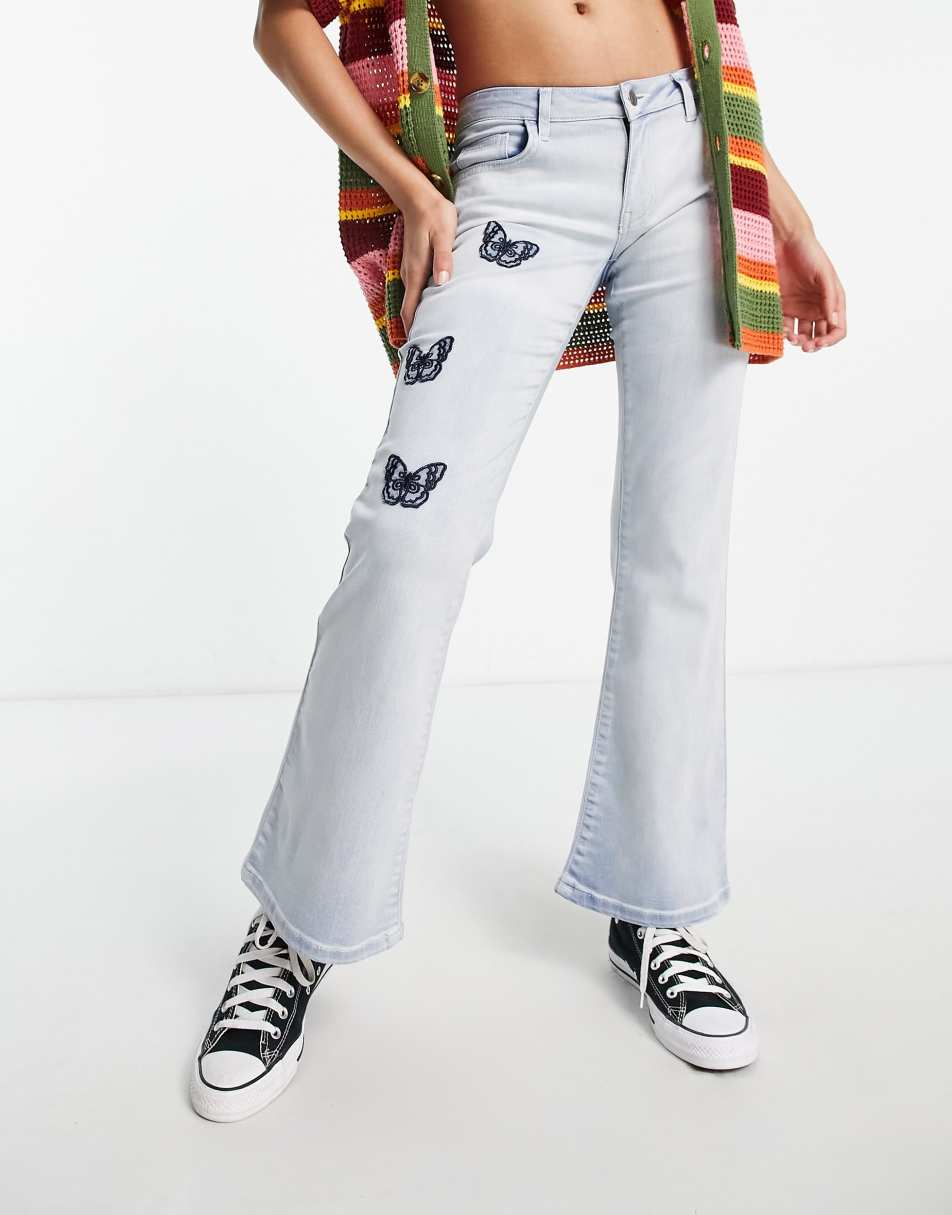 Reclaimed Vintage inspired low rise flare in bleach wash with butterfly embroidery