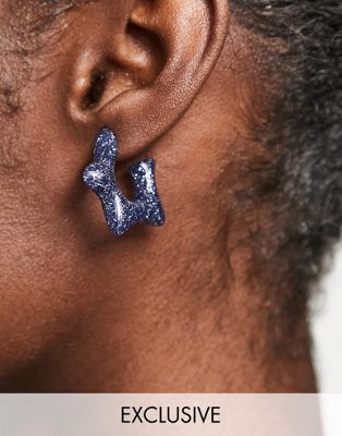 Reclaimed Vintage inspired star earrings in navy glitter resin