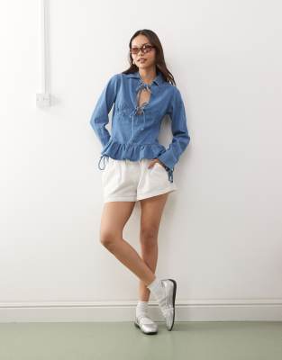 Reclaimed Vintage - Langärmliges Jeans-Oberteil in Mittelblau mit gebundener Vorderseite und Schößchensaum