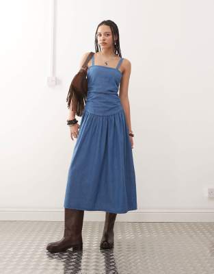 Reclaimed Vintage- Midi-Jeanskleid in mittelblauer Waschung mit tief angesetzter Taille und geraffter Partie