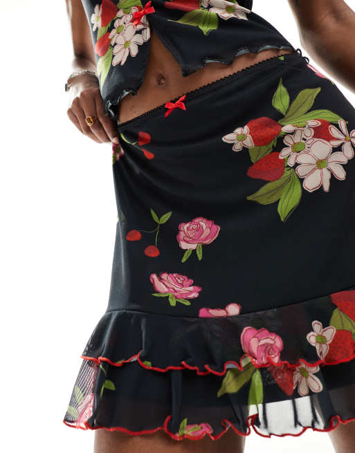 Reclaimed Vintage – Minirock in Schwarz mit Vintage-Blumen- und Obstmuster und Zierschleifen