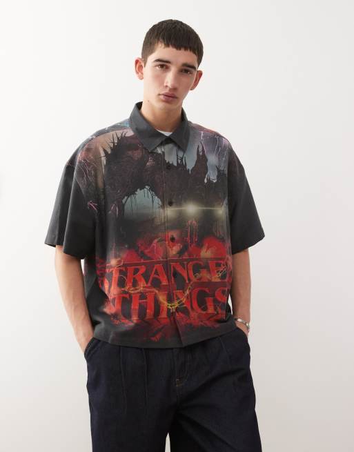 Reclaimed Vintage x Stranger Things – Kurzärmliges, kastiges Cropped-Hemd in verwaschenem Schwarz mit Logo