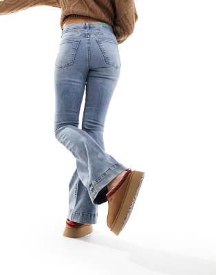 River Island - Ausgestelte Jeans in Mittelblau mit bauchkaschierendem Design