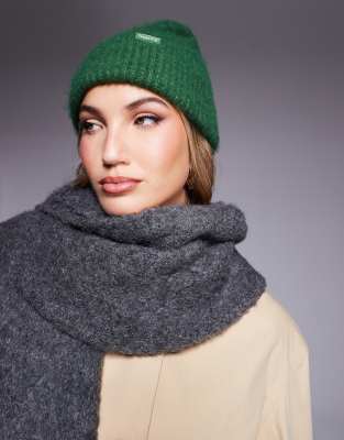 River Island - Flauschige Strickmütze in Dunkelgrün mit Schriftzug