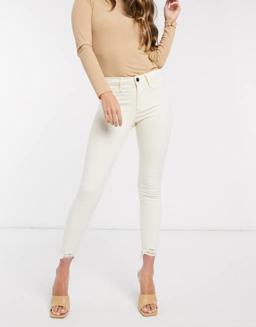 River Island Molly mid rise chewed hem skinny jeans in ecru ASOS