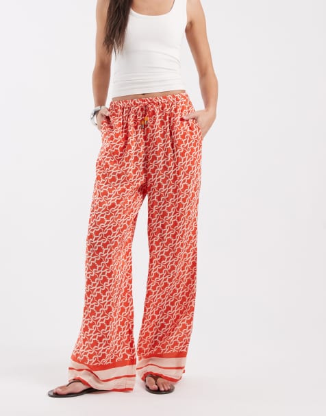 River Island monogrammed print pants in orange - view 1