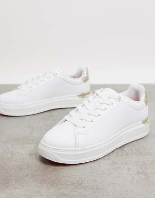 white sneakers with gold trim