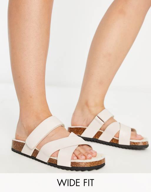 Sandalias beis planas con correas cruzadas de borreguito Fiery de ASOS DESIGN Wide Fit