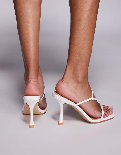 Sandalias blancas estilo mules de tacón medio con diseño de tiras