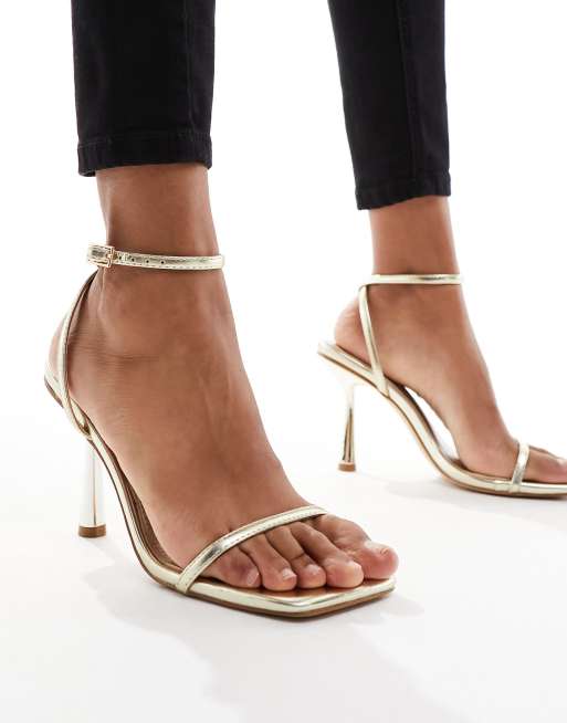 Sandalias doradas con diseño minimalista de tiras Damira de SIMMI London