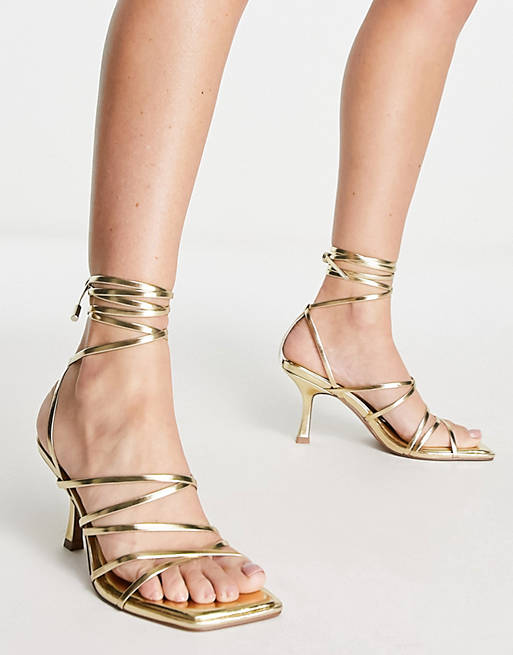Sandalias doradas con tacón medio y diseño de tiras anudadas a la pierna Hiccup de ASOS DESIGN 