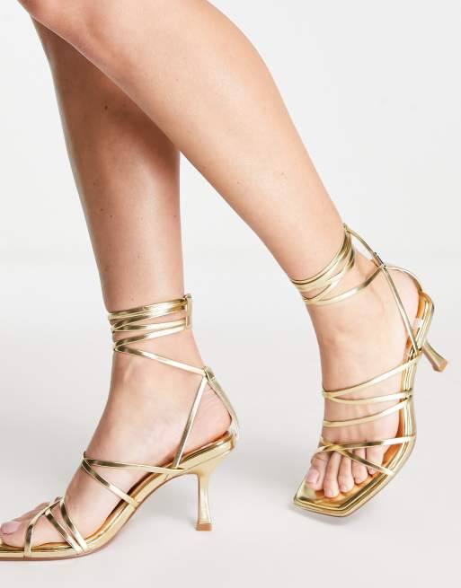 Sandalias doradas con tacón medio y de tiras anudadas a la pierna Hiccup de ASOS DESIGN | ASOS