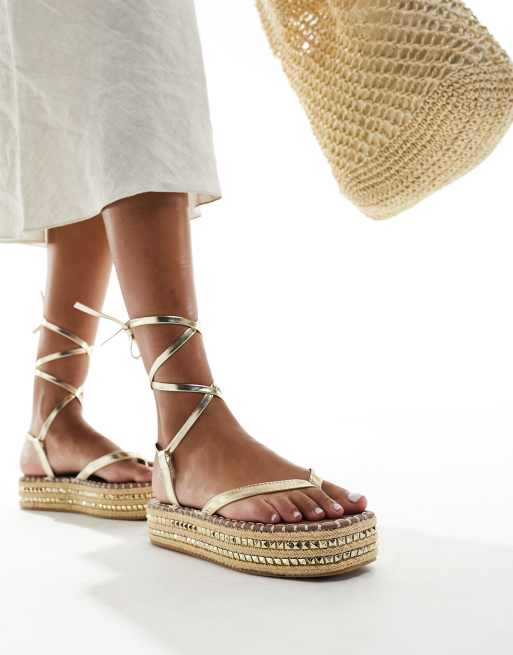 Sandalias doradas estilo alpargata con plataforma plana y detalle de tachuelas de South Beach