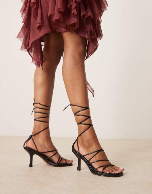 Sandalias negras con tacón medio y diseño de tiras anudado a la