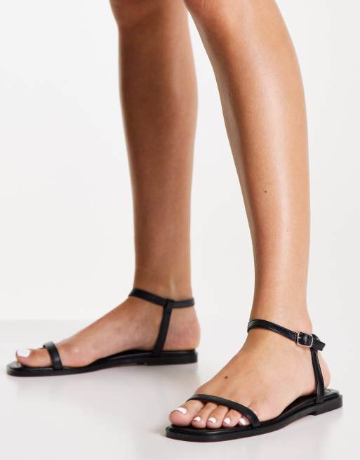 Sandalias negras planas con diseño minimalista de NA-KD