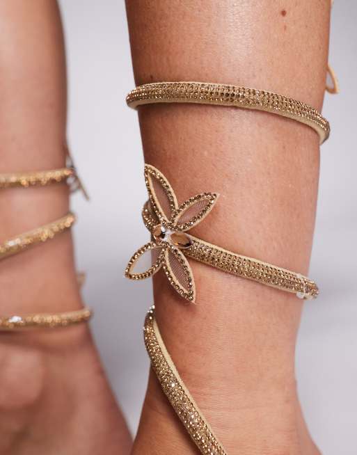 Sandalias planas doradas con diseño en espiral y detalle de