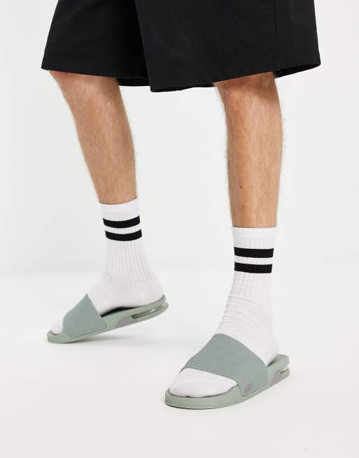Sandalias verdes con estampado de monograma y detalle abombado de River Island
