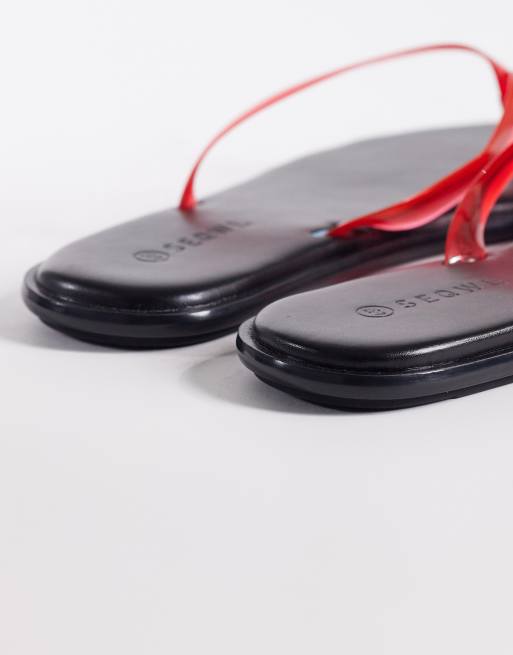 SEQWL jelly flip flops in black with red straps