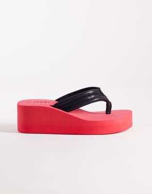 SEQWL Wide Fit - Zehenstegsandalen in Rot/Schwarz mit flacher Plateausohle und Keilabsatz, weite Passform