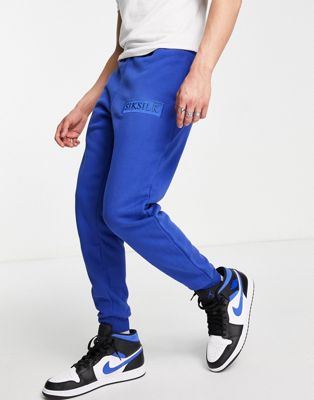 Siksilk joggers in blue with logo badge