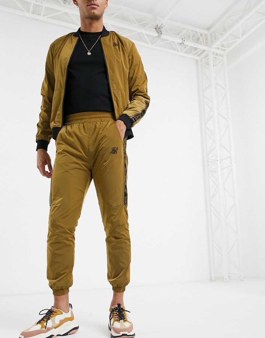 SikSilk nylon joggers in gold with logo side stripe