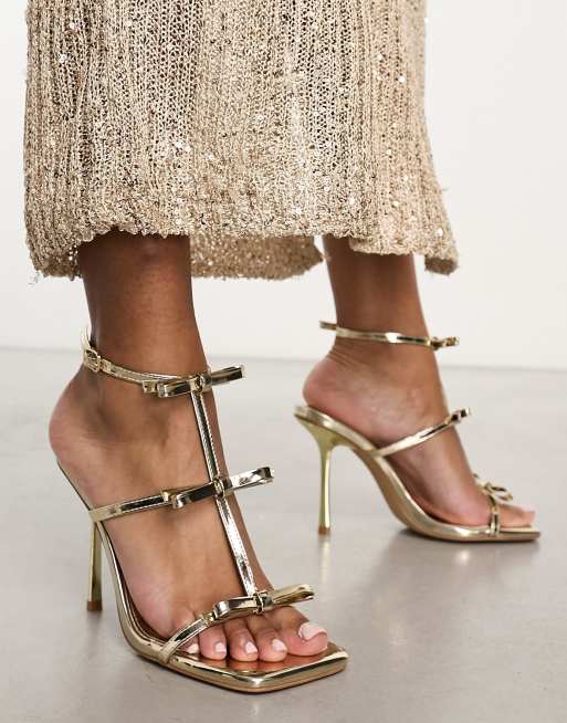 Simmi London - Exclusivité - Riva - Sandales à talon haut avec nœuds - Or effet miroir