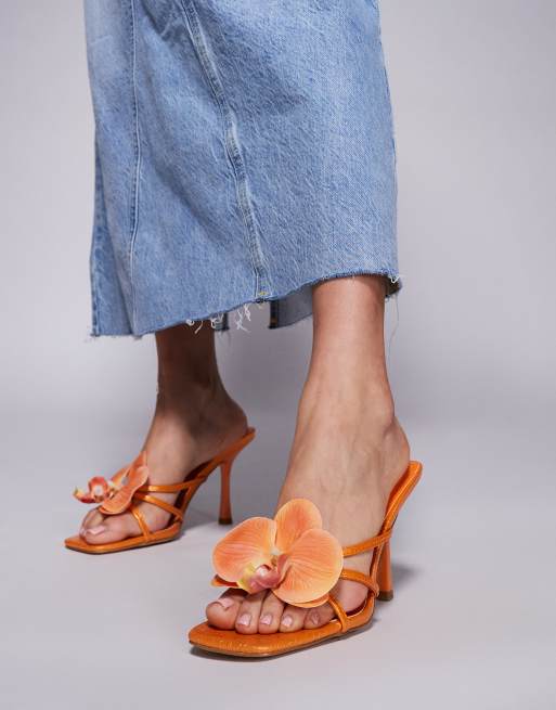 SIMMI London – Manaia – Sandaletten in Orange mit hohem Absatz und 3D-Blumenapplikation